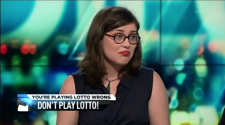 Image description: Screen capture of me (Liza) — white, fem, brunette with shoulder length hair and circle glasses — frowning with a TV graphic saying “You’re playing lotto wrong” and “Don’t play lotto”.